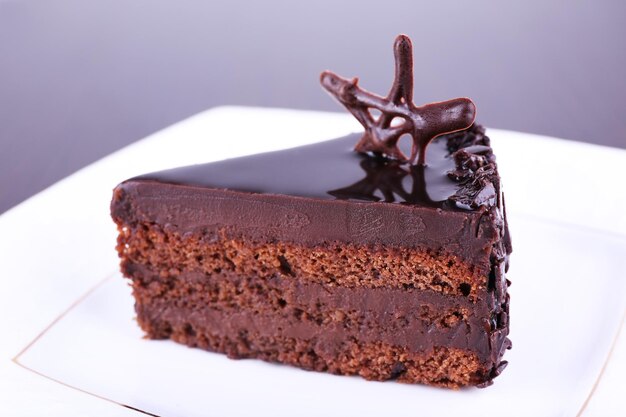 Delicious chocolate cake on plate on dark background