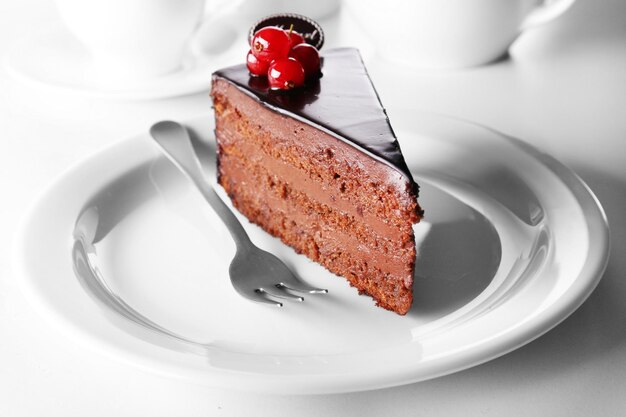 Delicious chocolate cake on plate on table on light background