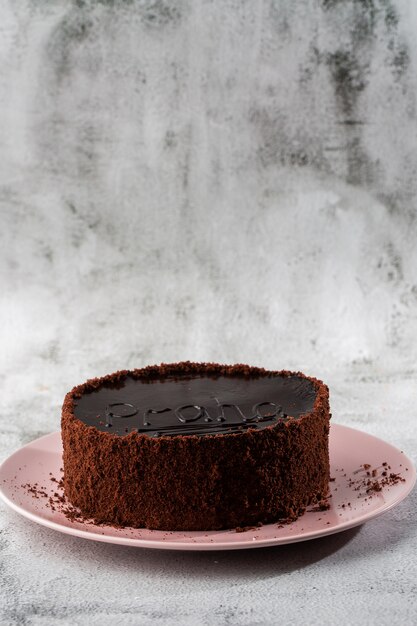 Delicious chocolate cake on plate on table on marble background. Wallpaper for pastry cafe or cafe menu. vertical.