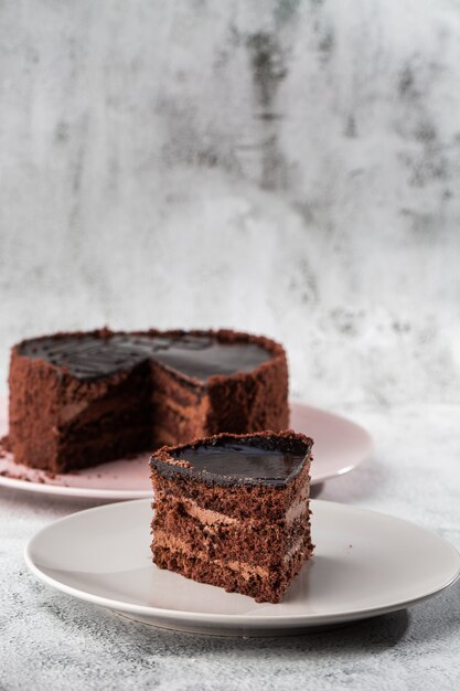 大理石の背景にテーブルの上の皿においしいチョコレートケーキ。ペストリーカフェやカフェメニューの壁紙。垂直。