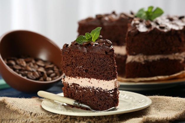 明るい背景のテーブルにおいしいチョコレートケーキ