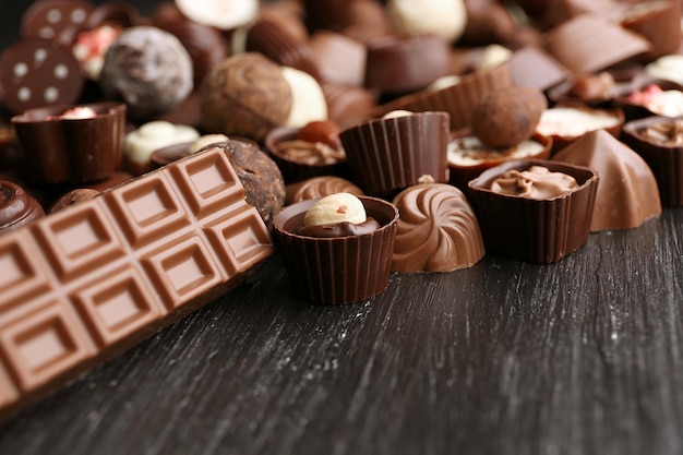 Delicious chocolate candies on wooden background close up