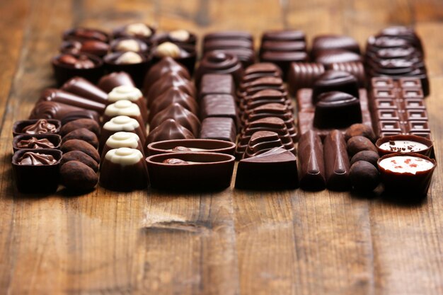 Delicious chocolate candies on wooden background