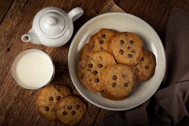 Delicious chocolate cookies with glass of milk on wooden table