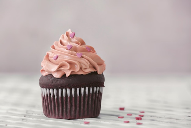 Delicious chocolate cupcake on table