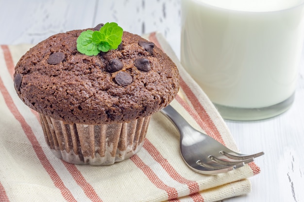 Фото Вкусный шоколадный кекс с шоколадной крошкой и стакан молока крупным планом