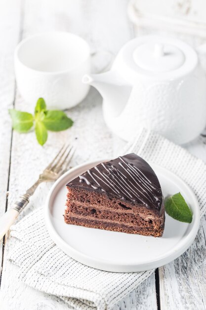 Delicious chocolate Prague cake on plate over white background