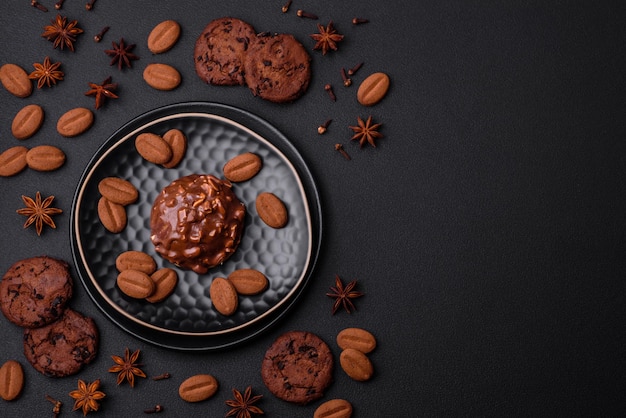 Delicious chocolate tart with nuts on a black ceramic plate on a dark concrete background