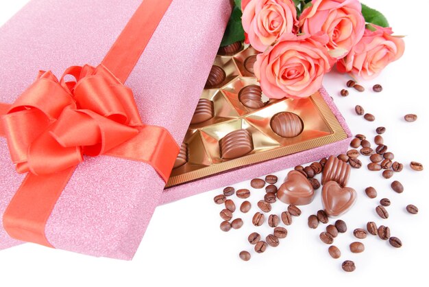 Delicious chocolates in box with flowers close-up