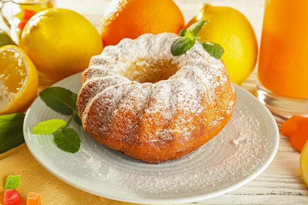 Delicious citrus cake with fruits on wooden table