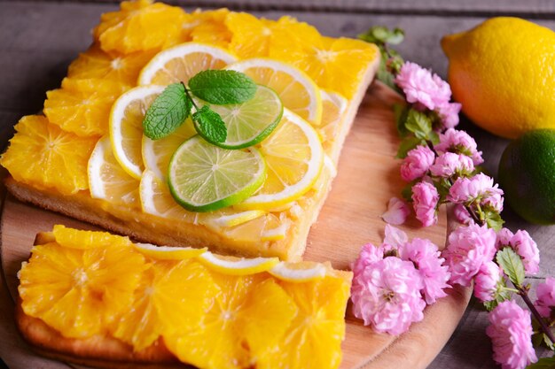 木製の背景においしい柑橘系のケーキ