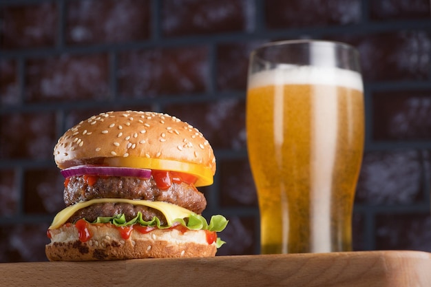 Delicious classic burger with a cutlet and a glass of cold beer Fast food is also harmful