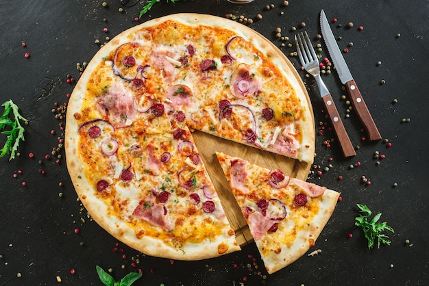 Delicious classic meat pizza on black background