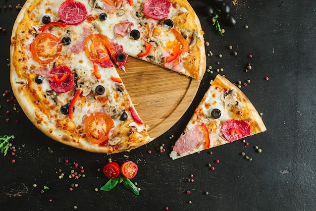 Delicious classic meat pizza on black background