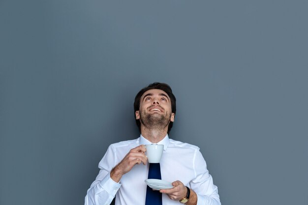 맛있는 커피. 그의 음료를 즐기면서 찾고 웃고 행복 긍정적 인 기쁘게 남자