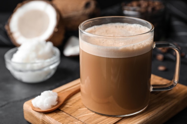 Delicious coffee with organic coconut oil on grey table