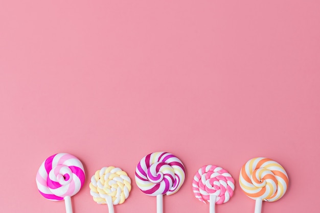 Delicious colourful of lollipop on pink background with copy space for snack food concept