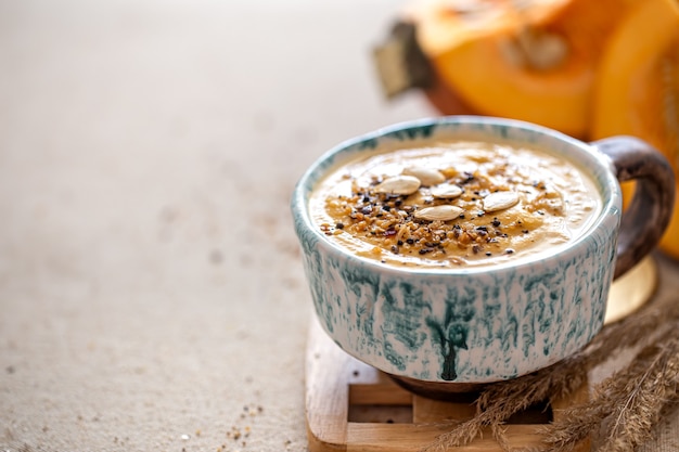 Foto deliziosa composizione con zuppa di zucca in un bellissimo piatto di ceramica. cibo stagionale.