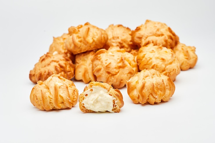 Photo delicious creamfilled profiteroles arranged on a dark slate surface perfect for dessert lovers