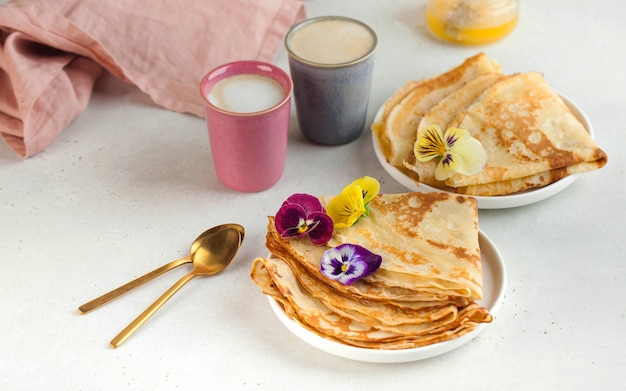 花とコーヒーマグで飾られた皿の上のおいしいクレープ