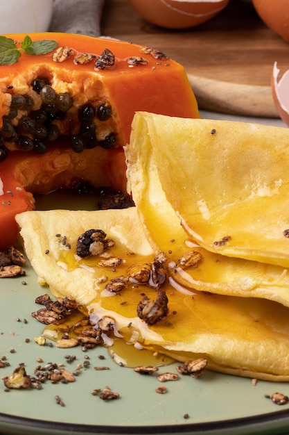 Delicious crepioca with granola and honey and papaya fruit.