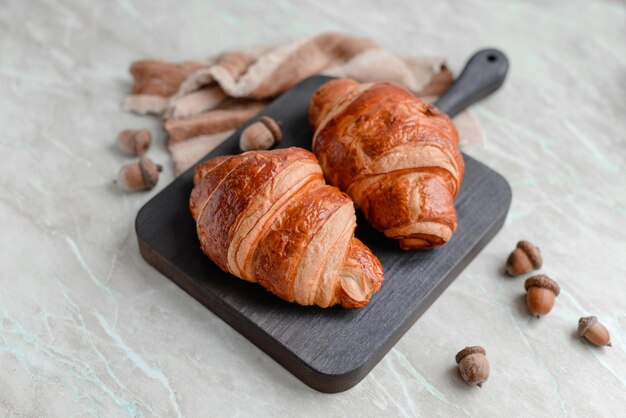 Delicious crispy croissant with chocolate with a cup of invigorating coffee on a light concrete background Delicious nutritious breakfast