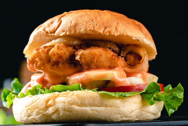 Delicious crispy fish burger with lettuce tomato onion ring and mayonnaise