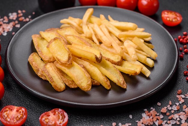 Delicious crispy french fries with salt and spices on a textured concrete background Fast food