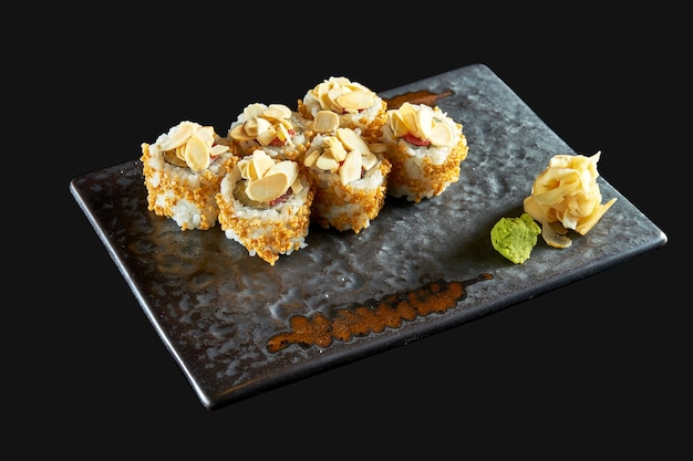 Delicious crispy sushi roll with tuna peanuts popcorn and cucumber served on a ceramic plate