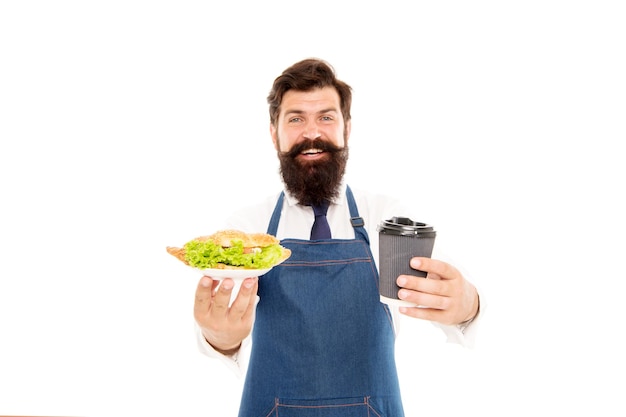 Delicious croissant. Enjoy your meal. Guy serving croissant stuffed lettuce and fresh vegetables. Healthy food. Combo meal. Cafe food concept. Man bearded waiter giving plate with food and coffee cup.