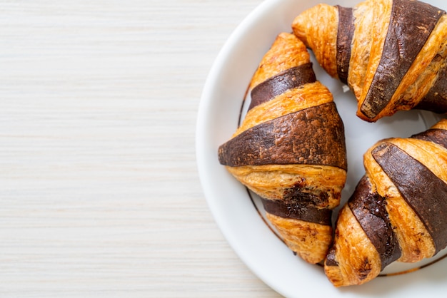 Delicious croissants with chocolate on plate