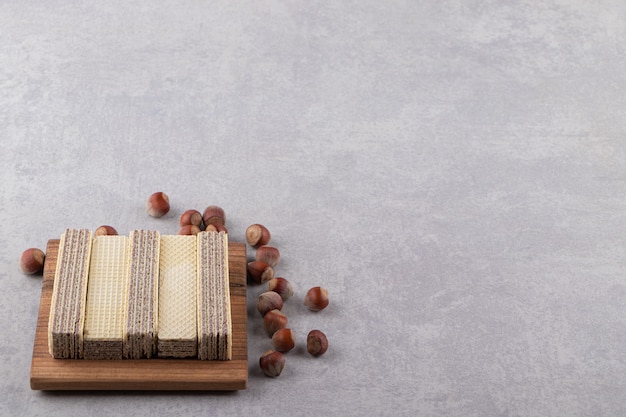 Delicious crunchy waffles and organic hazelnuts on stone table.