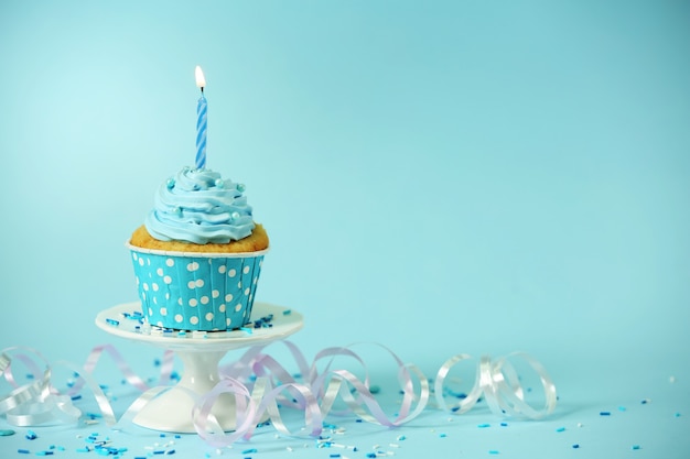 Delicious cupcake on table on blue