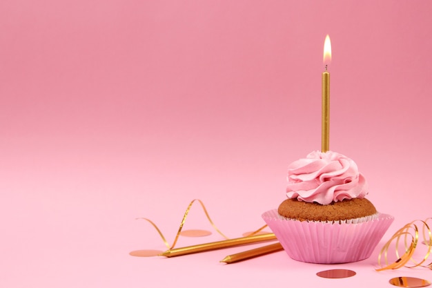 Delicious cupcake with a candle on a colored background with space for text