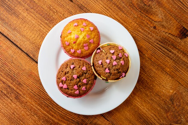 Delicious cupcakes with heart confectionery