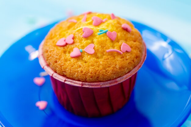 Delicious cupcakes with heart-shaped confectionery