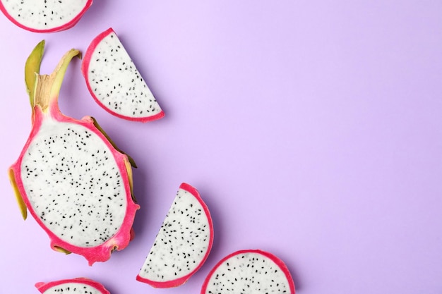 Вкусный нарезанный плод дракона питахайя на фиолетовом фоне плоской планировки Место для текста