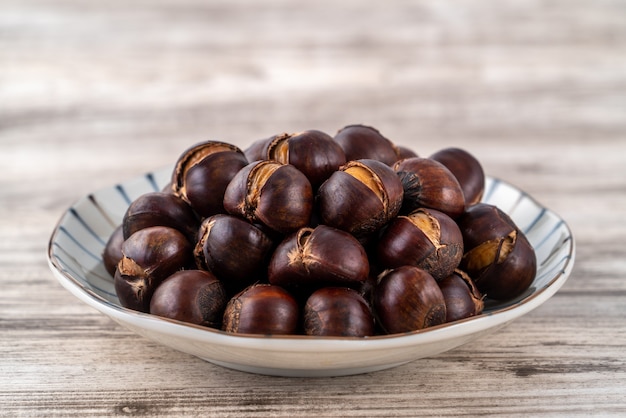 Castagne arrostite tagliate deliziose con olio e zucchero, spuntino sano nella vita, primi piani.