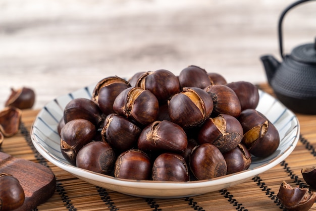 Delicious cut roasted chestnuts with oil and sugar, healthy eating snack in life, close up.