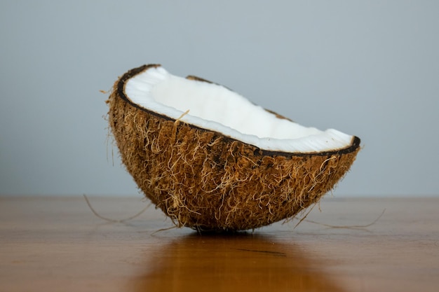 Deliziosa noce di cocco marrone disidratata su un tavolo di legno e sfondo di colore chiaro closeup foto