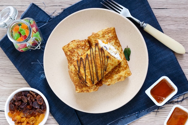 Delicious delicate pancakes with cottage cheese, vanilla and raisins on a plate. Healthy breakfast. Top view.