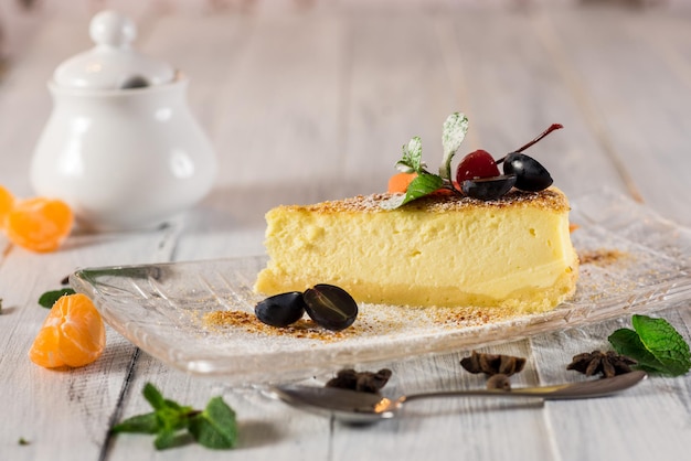 Deliziosa torta di formaggio da dessert con frutta su fondo di legno