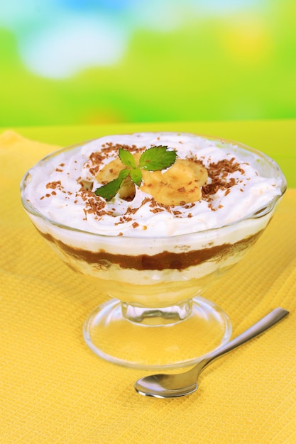 Photo delicious dessert with banana and caramel on table on bright background