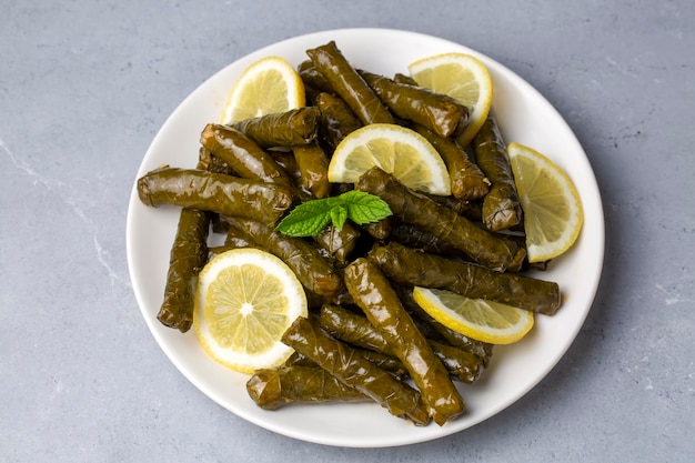 Delicious dolma sarma stuffed grape leaves rice white yogurt sauce Lebanese dolma sarma on plate Lebanon turkish greek middle eastern cuisine Turkish name Yaprak sarma