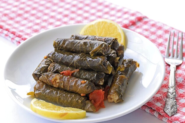 Delicious dolma sarma stuffed grape leaves rice white yogurt sauce Lebanese dolma sarma on plate Lebanon turkish greek middle eastern cuisine Turkish name Yaprak sarma