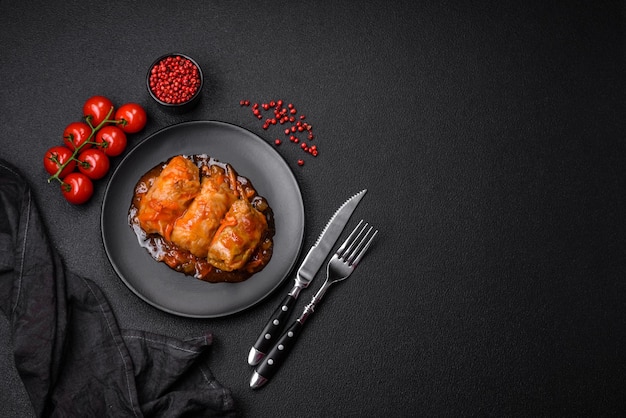 Delicious dolma in tomato sauce with carrots onions salt spices and herbs on a dark concrete background