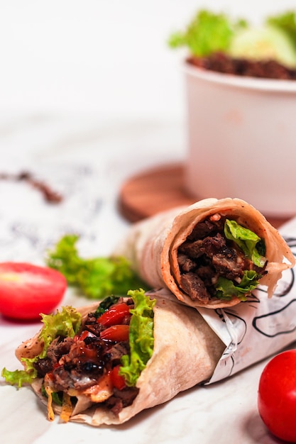 A delicious doner donair kebab wrap with spicy meat lettuce tomato red onion and sauce