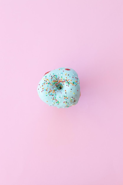 Delicious donut on color pink background
