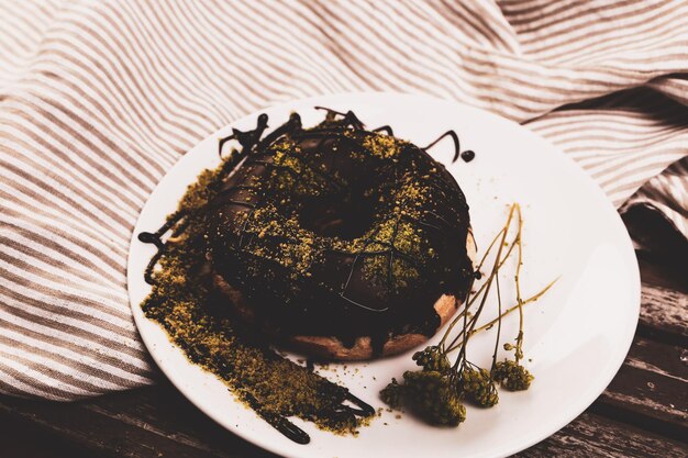 Delicious donut with chocolate sauce and pistachio nut pieces