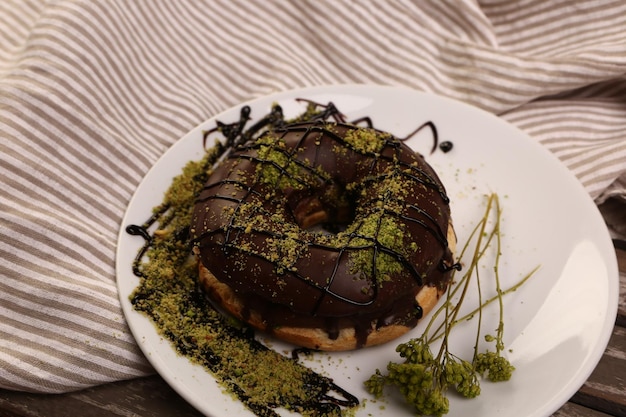 Delicious donut with chocolate sauce and pistachio nut pieces